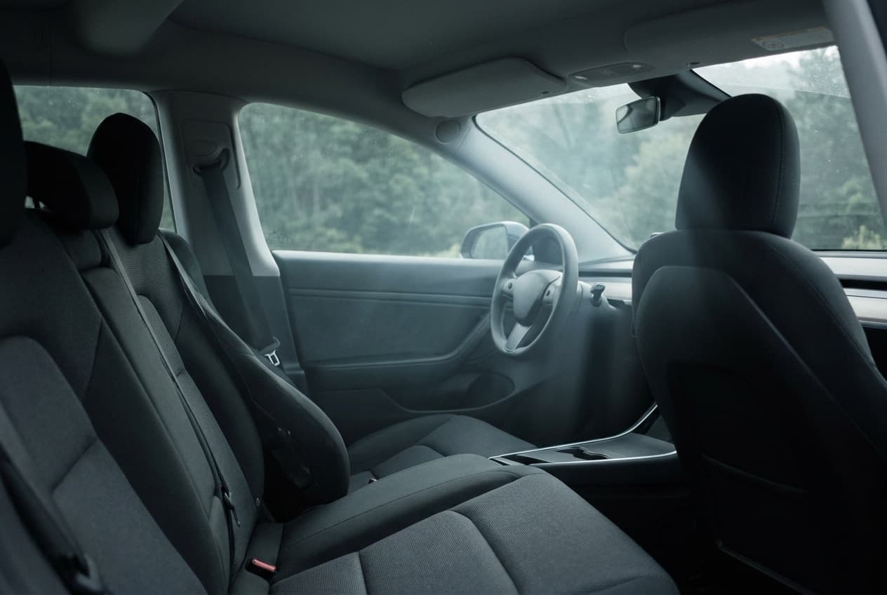 Het schone, lege interieur van een auto in de ochtend, gezien vanaf de achterbank door de voorruit.